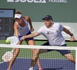 two pro players hitting the ball over a net